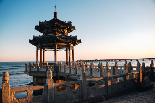 Buddhist pagoda on the beach with the sea in the background on a sunny day at sunset, Qinhuangdao, China - Powered by Adobe