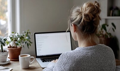 Woman using laptop at a wooden desk with coffee