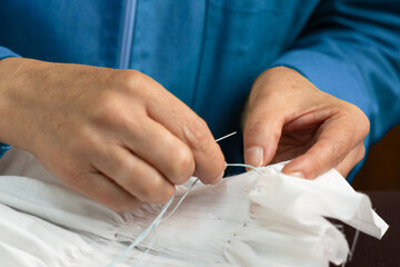 craftswoman embroidering a beautiful garment