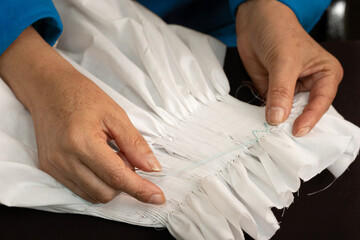 craftswoman embroidering a beautiful garment