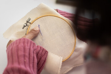 craftswoman embroidering a beautiful garment