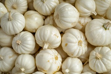 A bright orange pumpkin stands out among white pumpkins. The background is blurred.