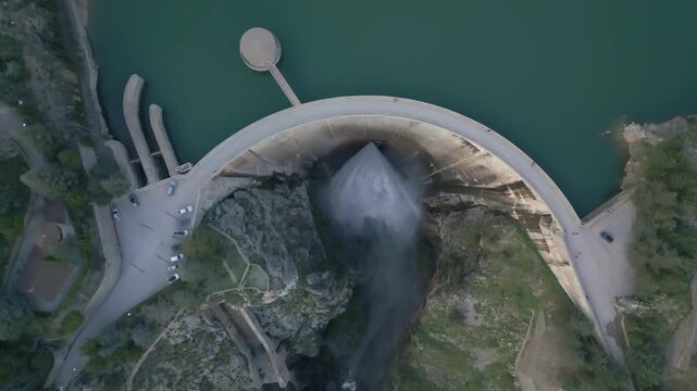 Dam discharges water from the reservoir. Aerial view of water realising from the dam. Howell Bunger valve in operation in vault dam. Quentar Reservoir. Spain.