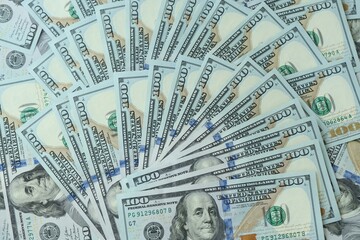 Many hundred dollar bills new banknotes in big pile under the natural light