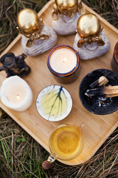 Tea with candles and various statues kept in wooden tray