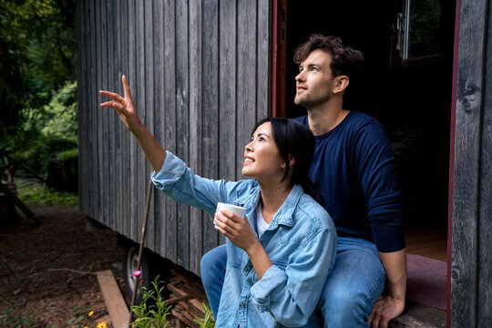 Smiling man with woman gesturing in doorway