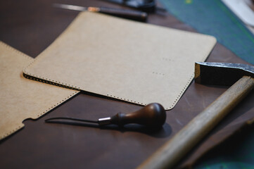 Crafting tools on natural cow leather in the tailoring workshop. Top view