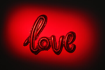 Red illuminated shiny balloon with love text