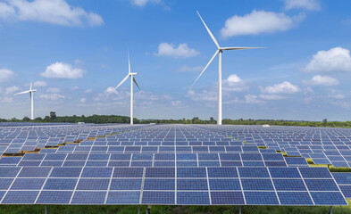    Rows array of Solar panels and wind turbines generating electricity in hybrid power plant...