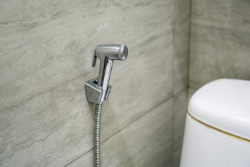 Close up of chromium bidet shower in a toilet. Handheld bidet in bathroom. © fery