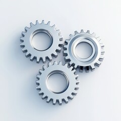 Three metallic gears arranged on a light background, symbolizing machinery and engineering.