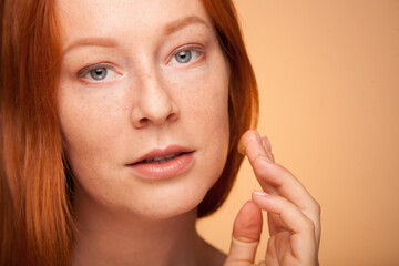 Fototapeta premium Hydration. Cream. Beuaty close up portrait of young woman with a healthy glowing skin is applying a skincare product