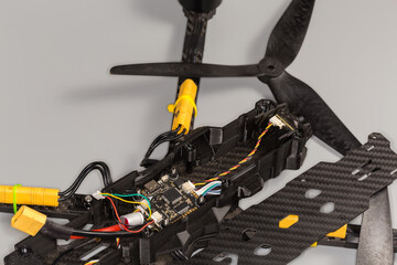 Fragment of partially assembled small quadcopter on a gray surface