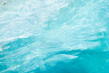 Fototapeta premium Closeup Transparent blue clear water surface texture with ripples. Abstract​ of​ surface​ blue​ splashes and bubbles​ water waves reflected​ with​ sunlight​