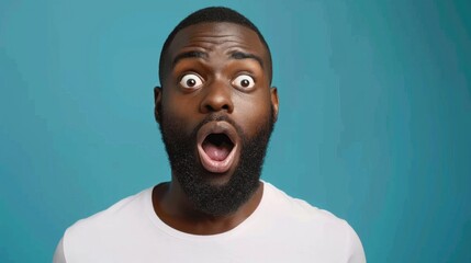 A surprised man in a white shirt displays shock and amazement against a bright blue background in a candid moment