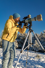 Amateur astronomer looking at the Sun trough a telescope with special solar filter.