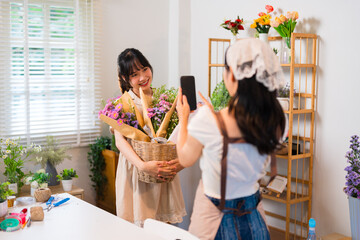 A florist taking a photo of a bouquet while another florist admires the creation, showcasing...