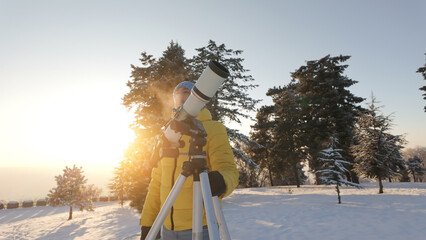 Amateur astronomer looking at the Sun through a telescope with special solar filter.