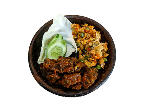 Paru Balado with spicy vegetable salad, and sliced cucumber on a cobek or plate made from clay. This is an traditional Indonesian menu for lunch or breakfast.