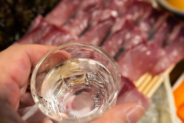 glass of soju on the yellowtail sashimi