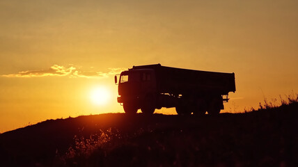 Naklejka premium silhouette of truck against vibrant sunset, showcasing beauty of nature and transportation. scene evokes sense of adventure and tranquility