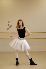 Ballerina in shoes and tutu, holding ballet slippers © Vagengeim