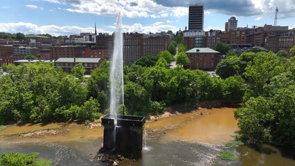 Langley Fountain with rainbow at Lynchburg, VA in James River beside downtown city skyline is historic landmark 