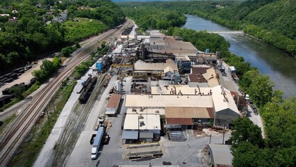 Old Industrial factory working beside James River in Lynchburg, VA with railroad in deep South on summer day