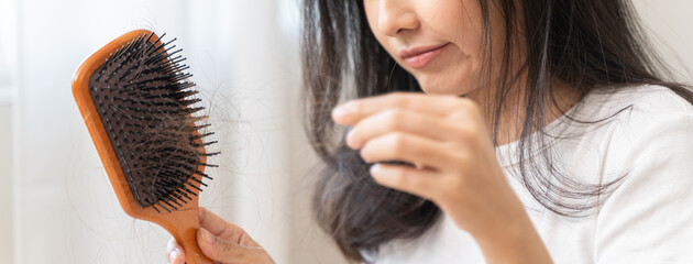 Close-up young woman brushing her hair and have many hair loss on the comb