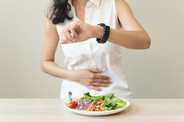 Intermittent Fasting eat concept, Woman looking at meal waiting time to eat during intermittent...