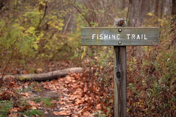 Weathered Engraved Wooden Sign Points Anglers Toward The Fishing Trail