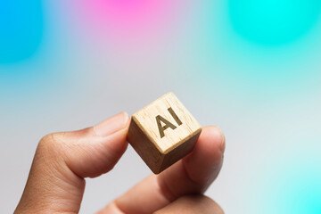 Hand Holding Wooden Block with 'AI' Inscription