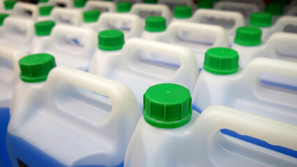 Close-up of many plastic canisters with blue liquid