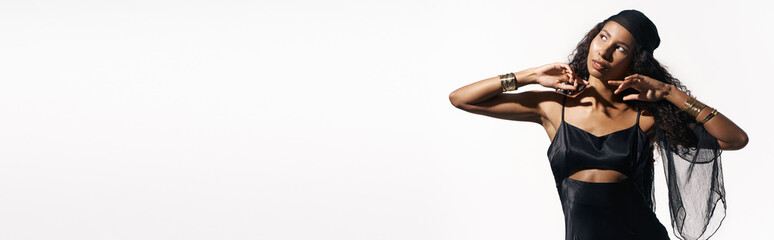 Fototapeta premium Stylish woman poses gracefully with a confident expression in modern fashion look and accessories