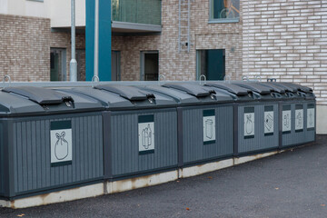 Plastic containers for separate waste collection. Bins for garbage separation outdoors on with...