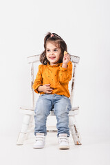 Smiling two-year-old girl with a biscuit in her hand on white background