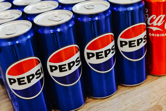 Kyiv, Ukraine - November 5, 2024: Close-up of neatly arranged Pepsi and Coca-Cola cans, showcasing a vibrant contrast of their iconic blue and red branding