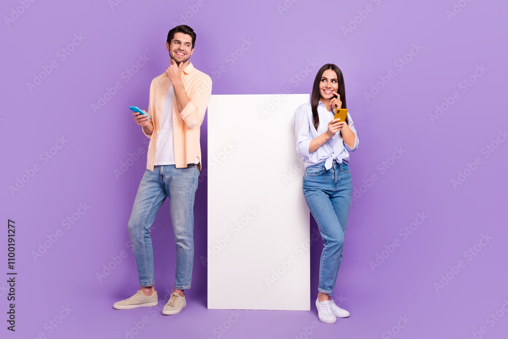Poster full length portrait of two minded funny people hold smart phone look curious empty space isolated o
