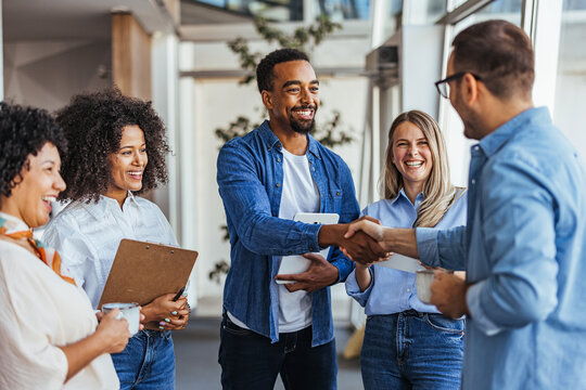 Diverse Team Meeting with Smiling Colleagues and Handshake