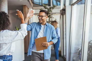 Two Colleagues Sharing a Successful High Five at Work