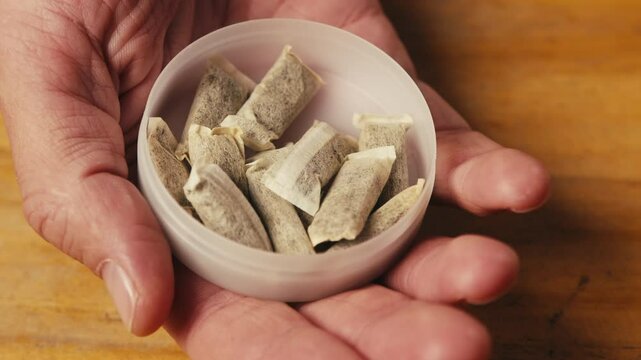 Snus nicotine tobacco close up, pack of tobacco for gum. unhealthy addiction. Man opening box with snus and taking one. 