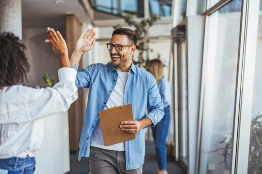 Two Colleagues Sharing a Successful High Five at Work