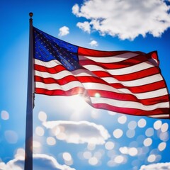 Obraz premium American flag waving against blue sky. US flag waving in the wind for Memorial Day or 4th of July