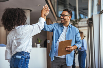 Cheerful Colleagues High-Fiving in Modern Office Setting