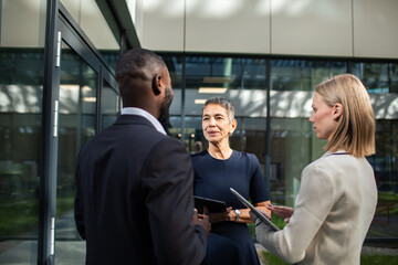 Business professionals discussing project outside office building
