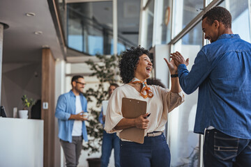 Colleagues Celebrating Success with a High Five in Office