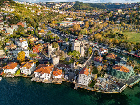 Aerial view of the historic anatolian fortress and scenic coastline along the bosphorus with greenery and urban buildings, Anadolu Hisari, Turkey.