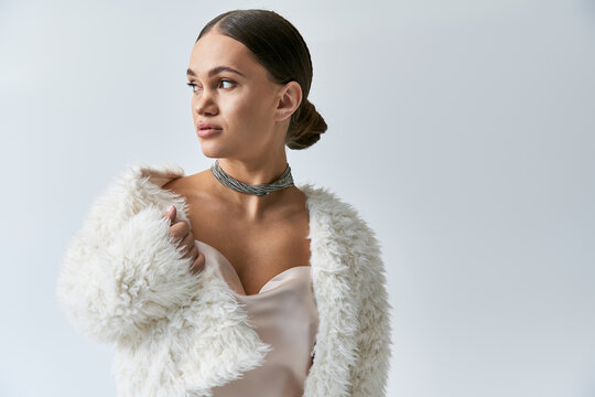 Fashionable young woman with achondroplasia showcases her exquisite style with a faux fur jacket.