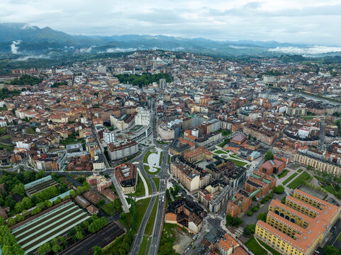 Aerial view of historic medieval buildings and scenic urban landscape with mountain backdrop, Oviedo City, Spain.