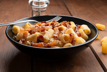 Mezze maniche alla gricia, ricetta tipica di pasta della cucina romana, cibo italiano 